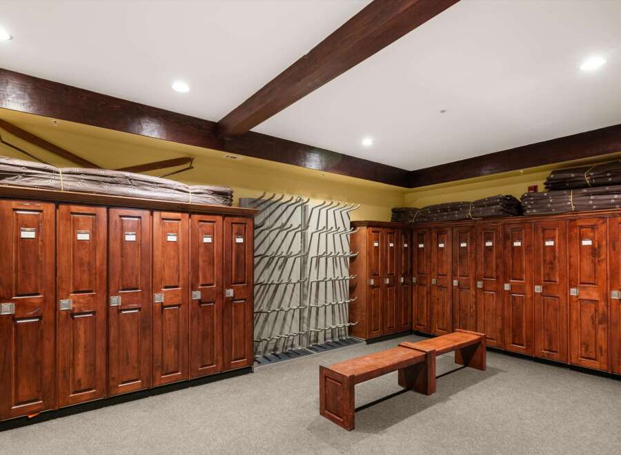 Discover this spacious locker room featuring rich wooden lockers with individual numbering and secure locking mechanisms.
