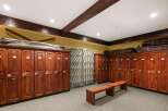 Discover this spacious locker room featuring rich wooden lockers with individual numbering and secure locking mechanisms.