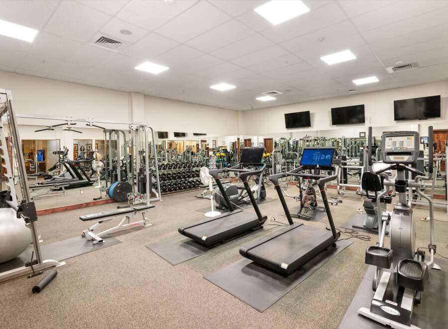 This spacious gym features a variety of cardio machines including treadmills and ellipticals, perfect for your fitness routine.