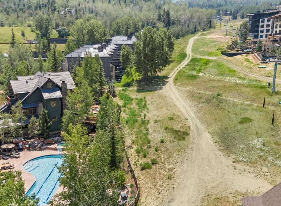 Experience luxury mountain living with this stunning property featuring a resort-style swimming pool and hot tub, perfect for relaxation after a day of adventure.