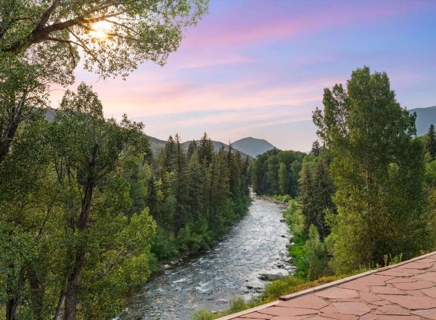 Experience the serene beauty of this mountain retreat, featuring a picturesque river flowing through lush greenery.