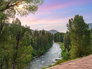 Experience the serene beauty of this mountain retreat, featuring a picturesque river flowing through lush greenery.