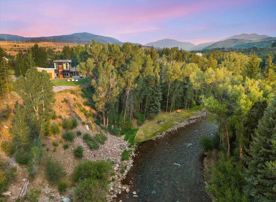 Experience luxury living with this stunning modern home nestled beside a serene river.