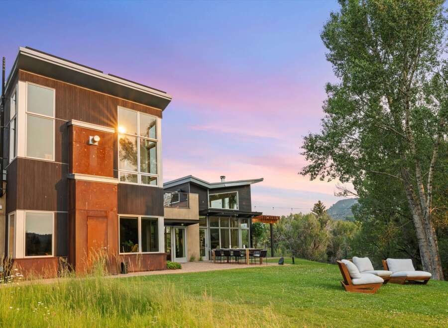 Experience modern luxury in this stunning architectural home, featuring expansive windows that capture breathtaking sunset views.
