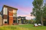 Experience modern luxury in this stunning architectural home, featuring expansive windows that capture breathtaking sunset views.