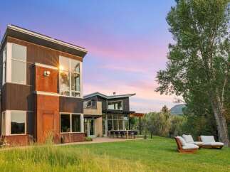 Experience modern luxury in this stunning architectural home, featuring expansive windows that capture breathtaking sunset views.