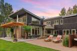 Experience modern luxury in this stunning home featuring dark wood siding and expansive windows that invite natural light.
