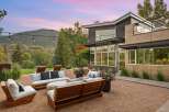 Experience luxurious outdoor living with this stunning patio featuring modern wooden furniture and plush cushions, perfect for relaxing or entertaining.