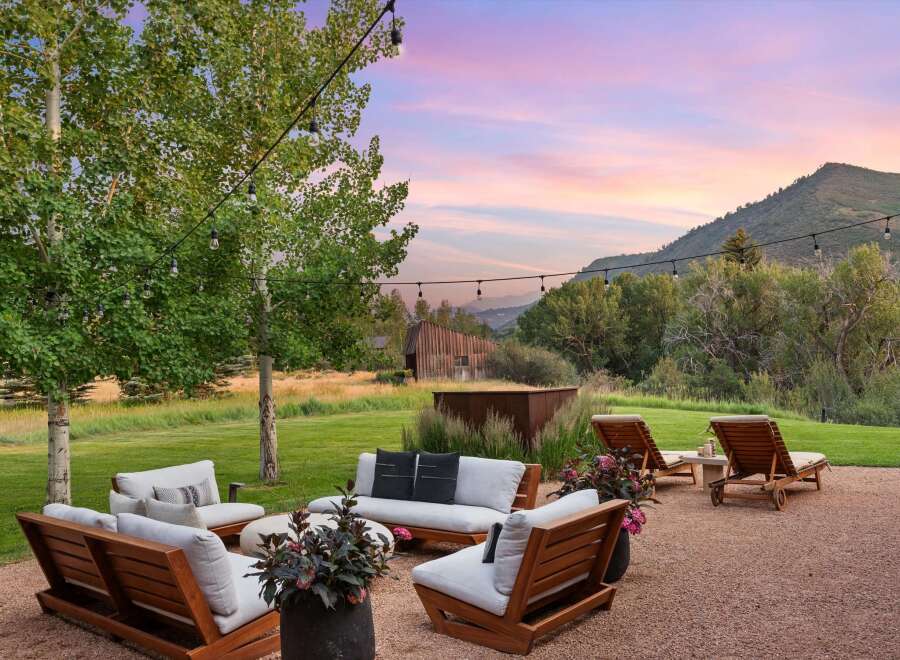 Experience serene outdoor living with this inviting patio space, featuring comfortable seating and lounge chairs perfect for relaxation.