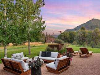 Experience serene outdoor living with this inviting patio space, featuring comfortable seating and lounge chairs perfect for relaxation.