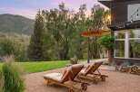 Experience luxury outdoor living with these elegant chaise lounges set against a stunning mountain backdrop.