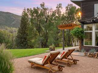 Experience luxury outdoor living with these elegant chaise lounges set against a stunning mountain backdrop.