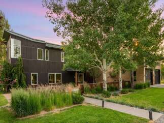 Experience modern luxury in this stunning home featuring a dark wood exterior and expansive windows that capture the natural light.