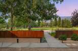 Experience modern luxury with this stunning property featuring a sleek concrete pathway leading through a serene landscape.