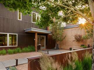 Experience modern living in this stunning home featuring dark wood siding and expansive windows that invite natural light.
