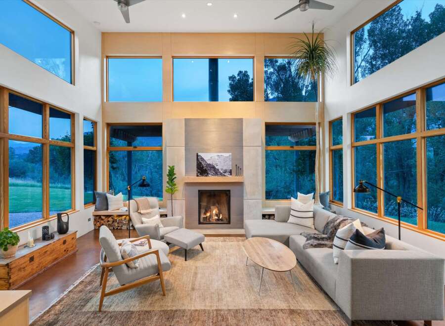 Experience modern living in this stunning great room, featuring soaring ceilings and expansive windows that flood the space with natural light and offer breathtaking views.