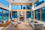 Experience modern living in this stunning great room, featuring soaring ceilings and expansive windows that flood the space with natural light and offer breathtaking views.
