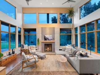 Experience modern living in this stunning great room, featuring soaring ceilings and expansive windows that flood the space with natural light and offer breathtaking views.