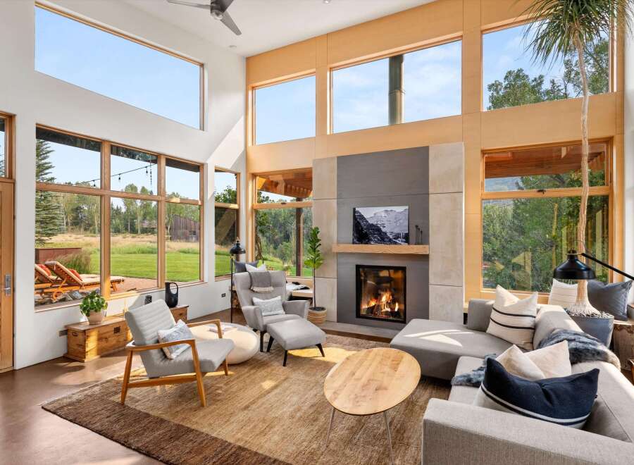 Experience modern living in this stunning great room, featuring soaring ceilings and expansive windows that flood the space with natural light and offer breathtaking views of the surrounding landscape.