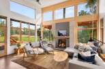 Experience modern living in this stunning great room, featuring soaring ceilings and expansive windows that flood the space with natural light and offer breathtaking views of the surrounding landscape.