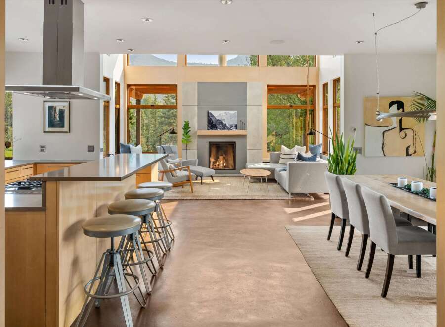 Experience modern living in this open-concept space, featuring a sleek kitchen island with bar stools and a stunning living area with a fireplace.