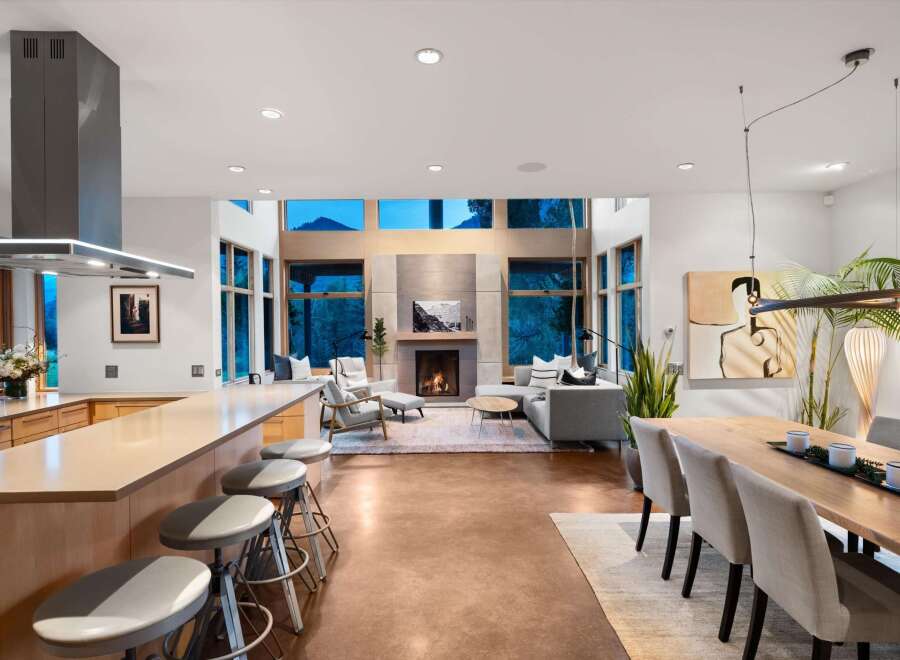 Experience modern living in this open-concept great room, featuring a sleek kitchen island with bar seating and a stunning fireplace as the focal point.