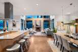 Experience modern living in this open-concept great room, featuring a sleek kitchen island with bar seating and a stunning fireplace as the focal point.