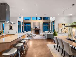 Experience modern living in this open-concept great room, featuring a sleek kitchen island with bar seating and a stunning fireplace as the focal point.