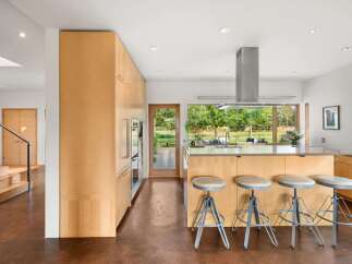 Experience modern living in this stunning kitchen featuring sleek, light wood cabinetry and a spacious island perfect for entertaining.
