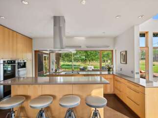 Experience modern living in this stunning kitchen featuring sleek, light wood cabinetry and a spacious island with bar seating.