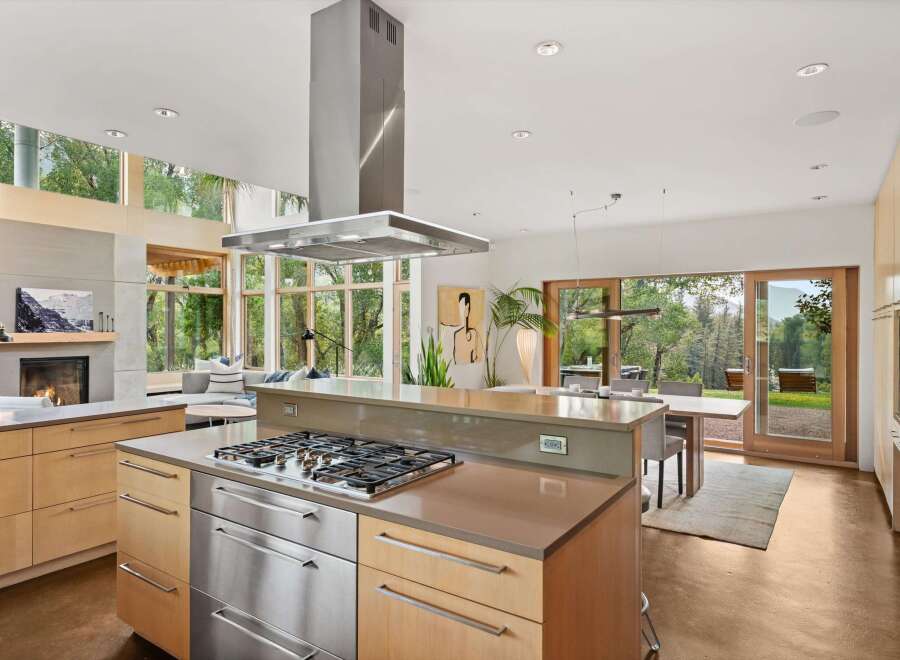 Experience modern living in this stunning open-concept kitchen and dining area, featuring a sleek gas range island and ample natural light.