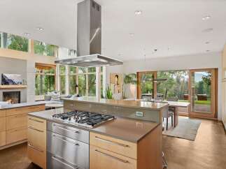 Experience modern living in this stunning open-concept kitchen and dining area, featuring a sleek gas range island and ample natural light.
