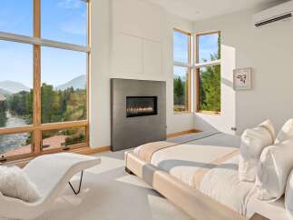 Experience luxury living with breathtaking mountain and river views from this stunning bedroom.