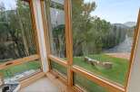 Experience breathtaking views from this stunning home, featuring expansive windows that frame a serene river and lush forest.