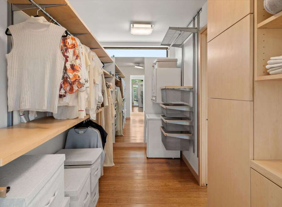 Discover this spacious walk-in closet, featuring ample hanging space for your wardrobe and organized shelving solutions.