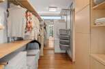 Discover this spacious walk-in closet, featuring ample hanging space for your wardrobe and organized shelving solutions.