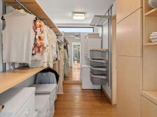 Discover this spacious walk-in closet, featuring ample hanging space for your wardrobe and organized shelving solutions.