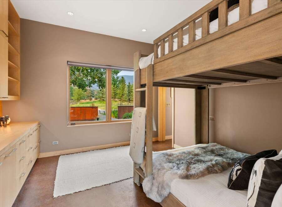 This charming bedroom features a rustic wooden bunk bed, perfect for accommodating guests or family.