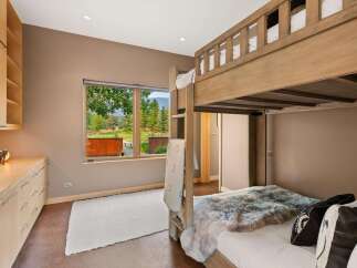 This charming bedroom features a rustic wooden bunk bed, perfect for accommodating guests or family.