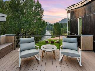 Experience breathtaking mountain and river views from this stunning modern deck, perfect for enjoying serene sunsets.
