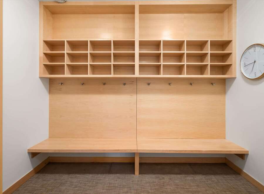 This modern entryway features a built-in wooden bench with ample cubby storage above, perfect for organizing shoes and accessories.