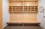 This modern entryway features a built-in wooden bench with ample cubby storage above, perfect for organizing shoes and accessories.