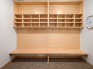 This modern entryway features a built-in wooden bench with ample cubby storage above, perfect for organizing shoes and accessories.