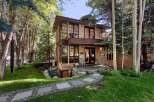 Nestled amidst lush greenery and mature trees, this modern stone home offers a unique architectural design.