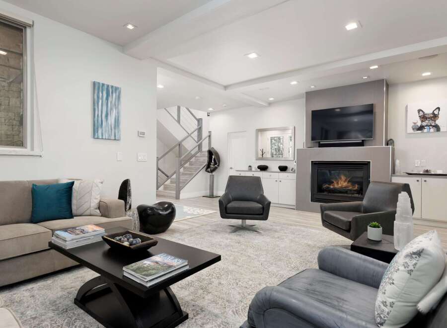 Experience modern luxury in this stunning living room, featuring a sleek fireplace and comfortable seating arrangements.