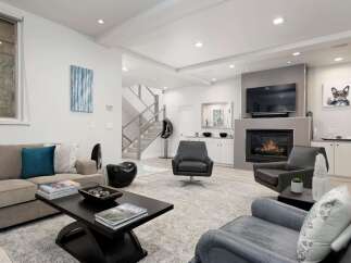Experience modern luxury in this stunning living room, featuring a sleek fireplace and comfortable seating arrangements.