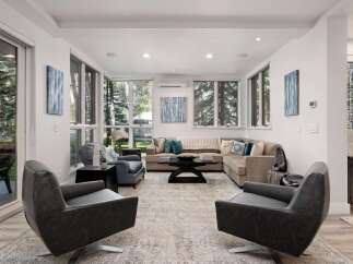 Experience modern living in this spacious living room, featuring a large sectional sofa and comfortable armchairs perfect for relaxation.