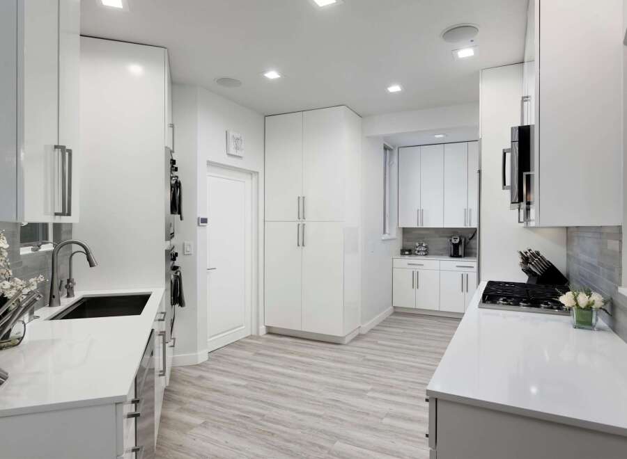 Experience modern luxury in this stunning white kitchen, featuring sleek cabinetry, a deep undermount sink, and a professional-grade gas range.