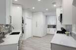 Experience modern luxury in this stunning white kitchen, featuring sleek cabinetry, a deep undermount sink, and a professional-grade gas range.
