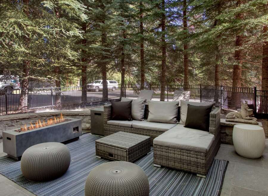 Enjoy outdoor living with this stylish patio featuring a modern gas fire pit and comfortable sectional seating.
